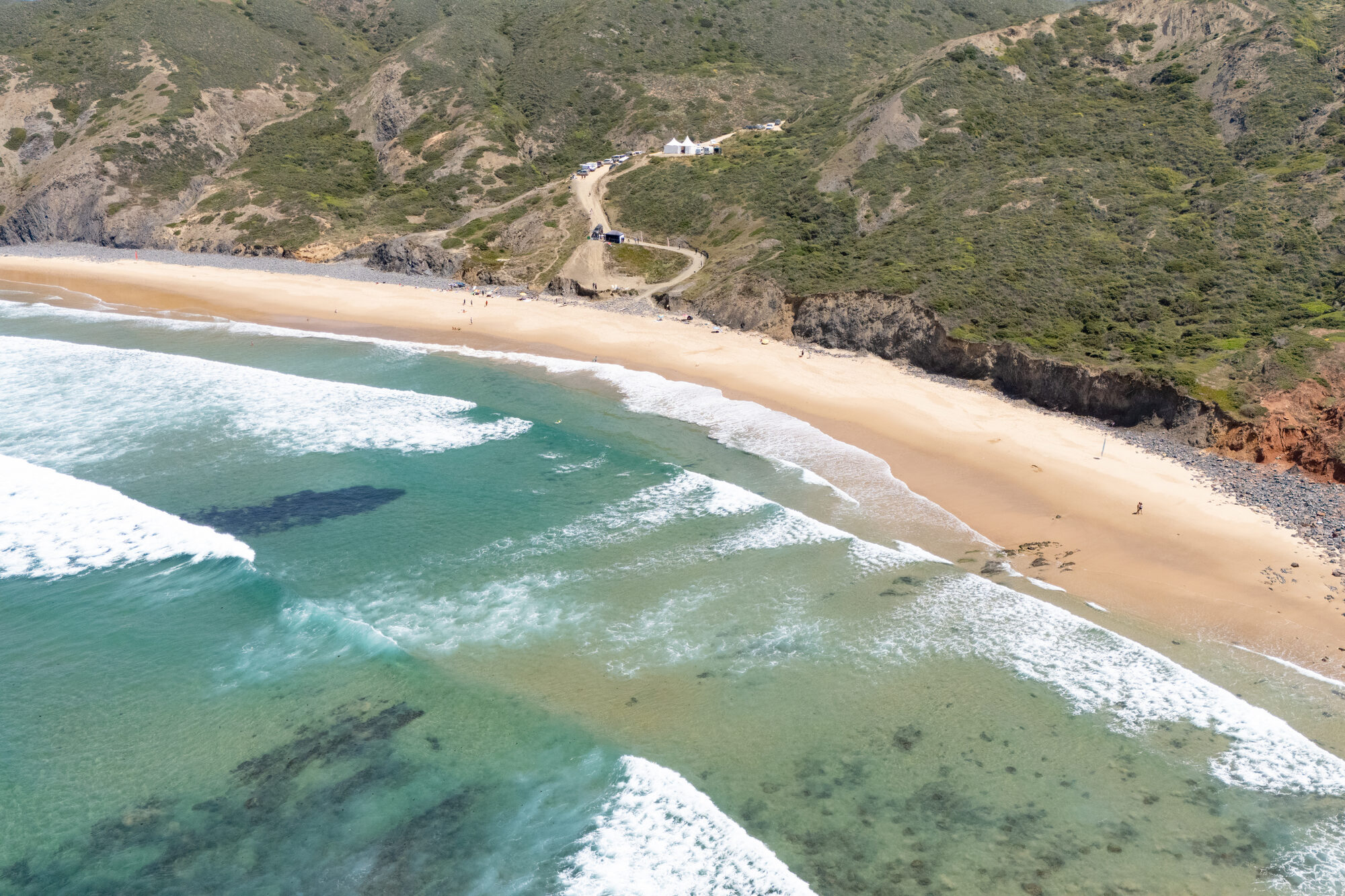 Turquoise Atlantic water meeting a wide Algarve beach, seen from above