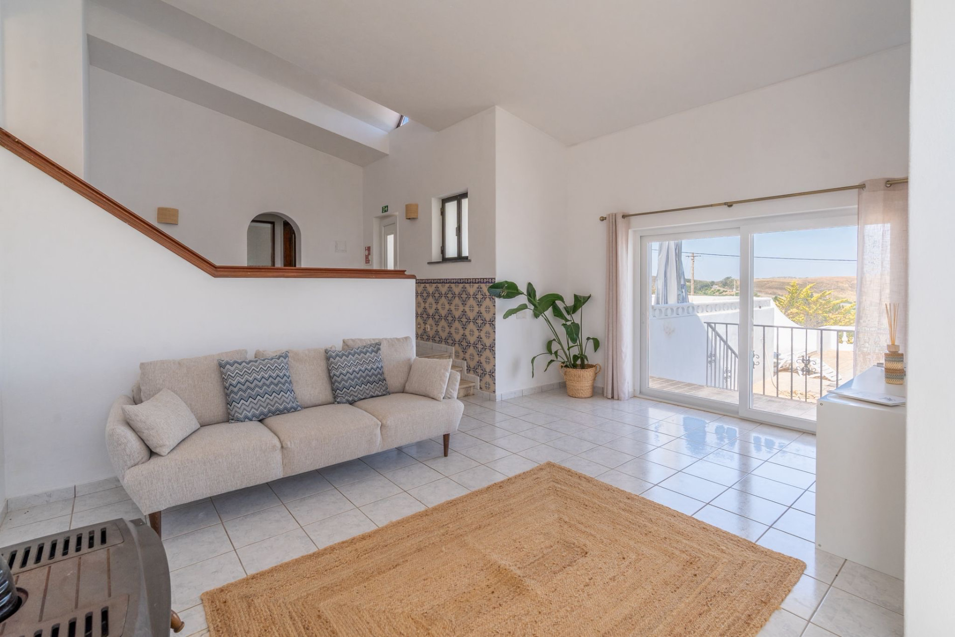 Living space with azulejo tiles, jute rug and balcony doors