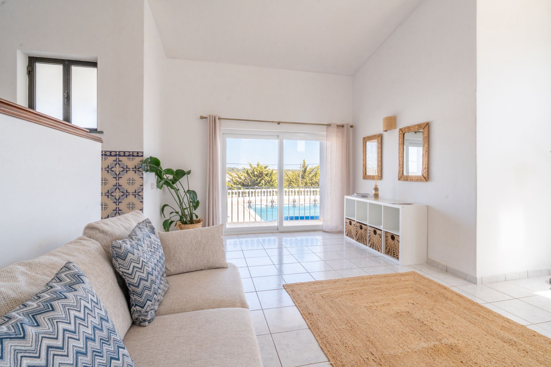 Bright living room with sofa and sliding doors opening onto the pool